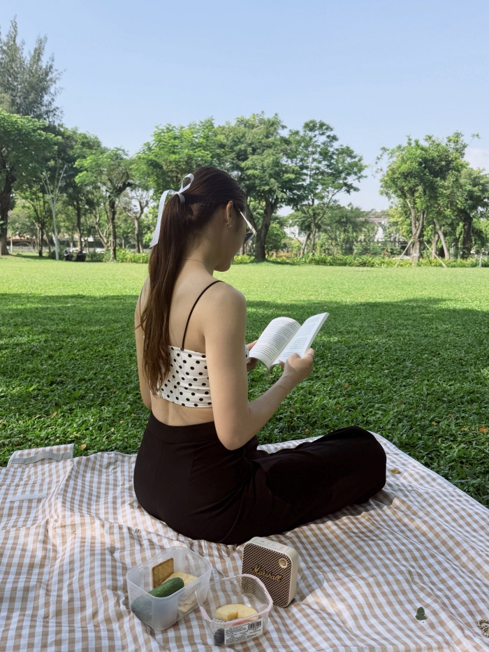 Đây là minh chứng rõ nét nhất cho thành quả của việc chăm sóc bản thân và giữ gìn vóc dáng. Gu thời trang của cô đề cao sự thoải mái nhưng vẫn phải đảm bảo tính thẩm mỹ cao. Cách cô chọn phụ kiện như kính mắt gọng vàng và kiểu tóc buộc thấp tinh tế cho thấy một tư duy thời trang ổn định, luôn biết cách làm mình nổi bật giữa không gian xanh mướt của thiên nhiên.