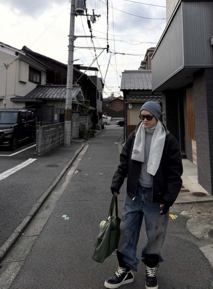 Ở outfit dạo phố, JSOL lựa chọn áo khoác bomber đen form rộng kết hợp cùng quần jeans ống suông và sneaker cổ cao. Tổng thể mang hơi hướng streetwear, nhưng được tiết chế để không quá hầm hố.