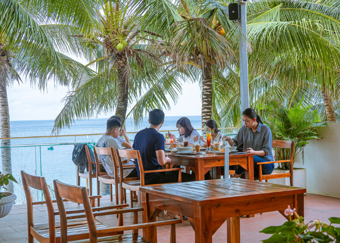 Các bàn ăn trong nhà sát lan can là vị trí tuyệt đẹp để ngắm biển