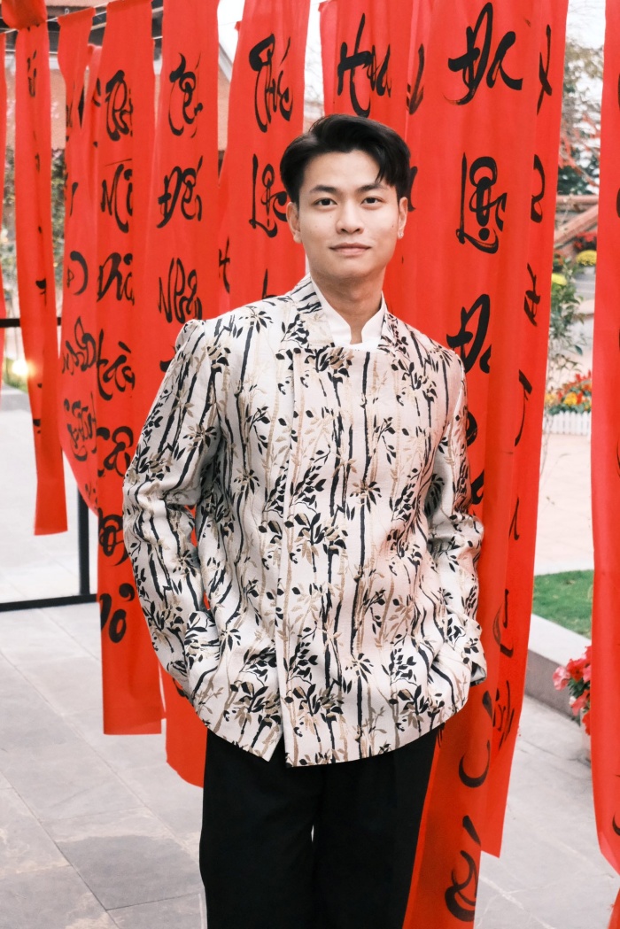 Ninh Anh Bùi diện áo dài họa tiết, tạo dáng giữa không gian câu đối đỏ, gợi không khí Tết truyền thống.