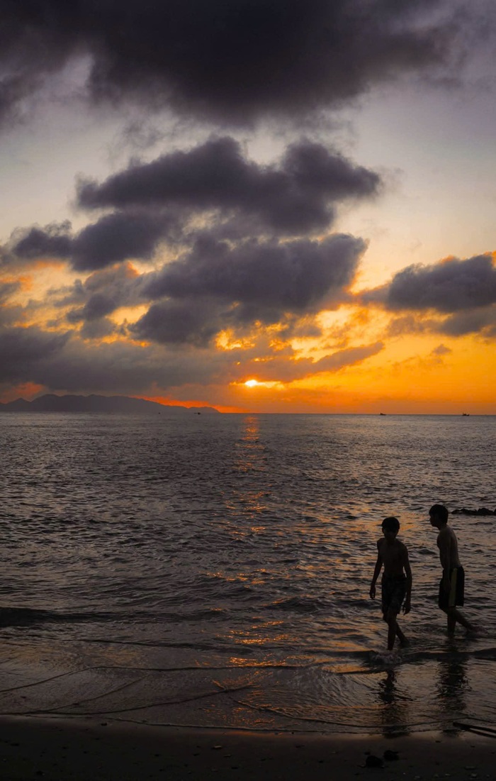 Ở bãi biển, hai em nhỏ đi dạo và nô đùa dưới ánh chiều muộn. Ảnh: Tuấn Thành