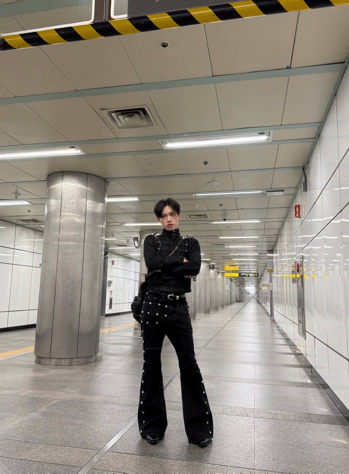 Ở set đồ đen, Pháp Kiều lựa chọn áo cổ cao dáng ôm, thiết kế là với hàng nút và chi tiết dây đai mang hơi hướng military. Phần thân áo ôm gọn giúp tôn lên vóc dáng, đồng thời tạo cảm giác gọn gàng, tôn dáng. Kết hợp cùng đó là quần ống loe đen, điểm nhấn bằng các chi tiết kim loại chạy dọc hai bên, vừa tạo hiệu ứng kéo dài đôi chân, vừa tăng thêm độ “edgy” cho tổng thể.