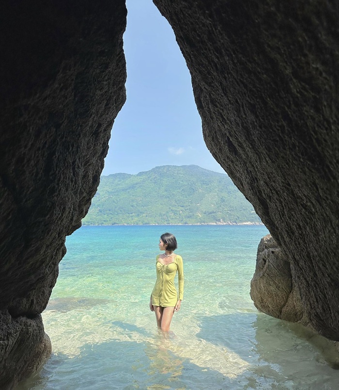 Khung cảnh được bao bọc bởi những vách đá cao, mở ra tầm nhìn hướng biển xanh và núi non phía xa, tạo nên bức tranh thiên nhiên thanh bình, cuốn hút. 