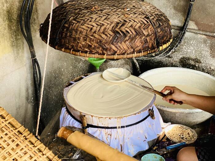 Tráng lớp bột gạo trên bàn trơn để làm bánh đa Thổ Hà