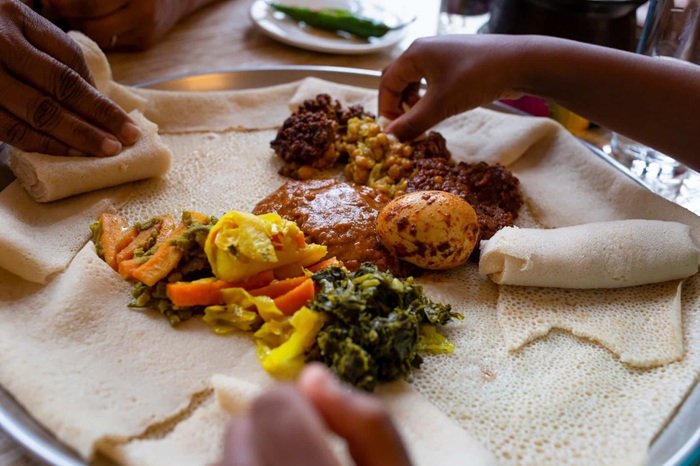 Bánh mì dẹt Injera để cuốn thức ăn thể hiện một nét văn hóa ẩm thực châu Phi đại diện cho sự sẻ chia - Ảnh: Remitly